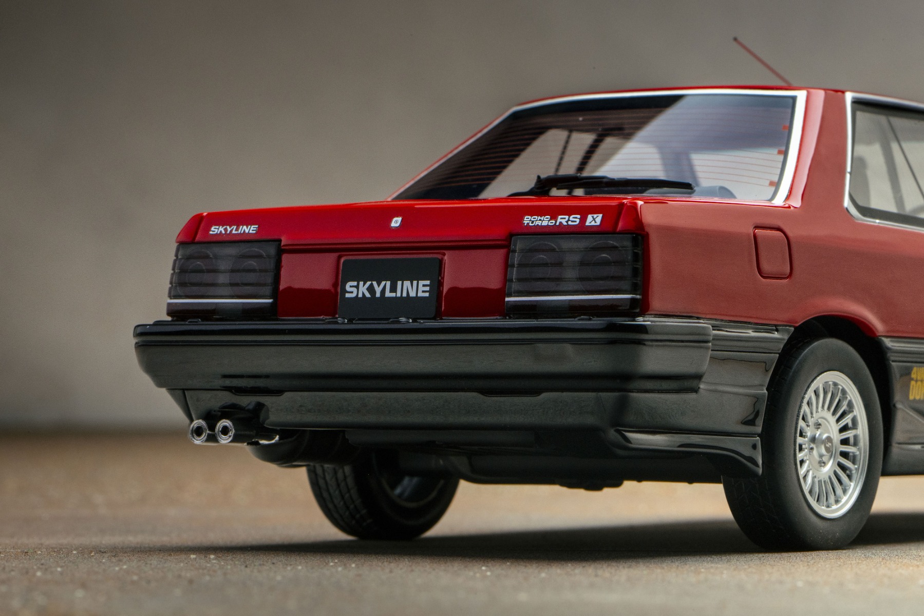 丸形テールランプはスカイラインの象徴。後期型で鉄仮面マスクになるとともに、テールランプもスリットの入ったスモークタイプに変更されました。デュアルエキゾーストも見事に表現されています。