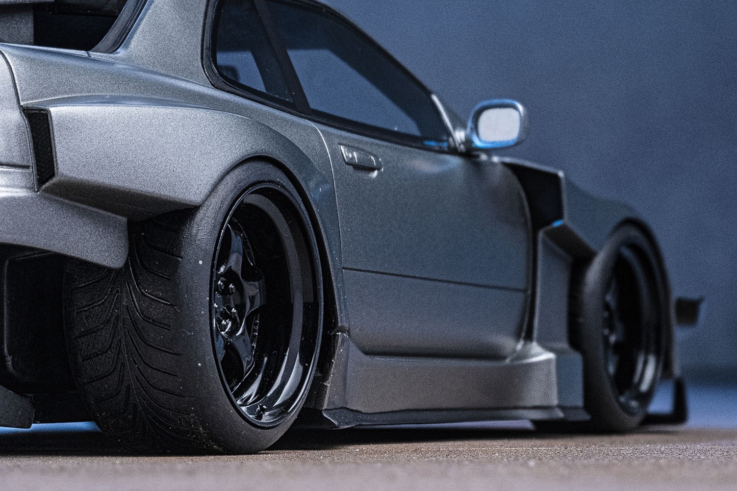 ワイドなブリスターフェンダーに収まるのはワーク・マイスターS1の3ピース。ブラックディスク／ブラックリムのコンビネーションがR34GT-Rの迫力をいっそう高めます。大きなサイズのカナードも見どころ。