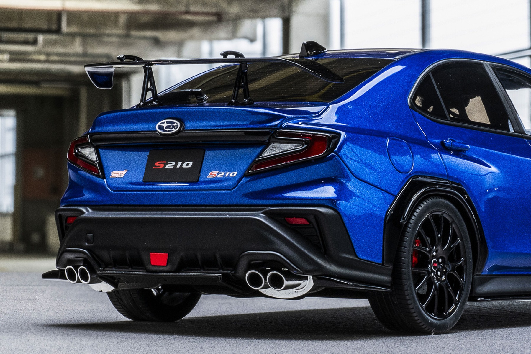 スワンネックタイプのドライカーボン製リアスポイラーやSTIリアアンダーディフューザーを装着することで空力性能が向上。本製品ではSTIエンブレムや専用オーナメントも忠実に再現しています。