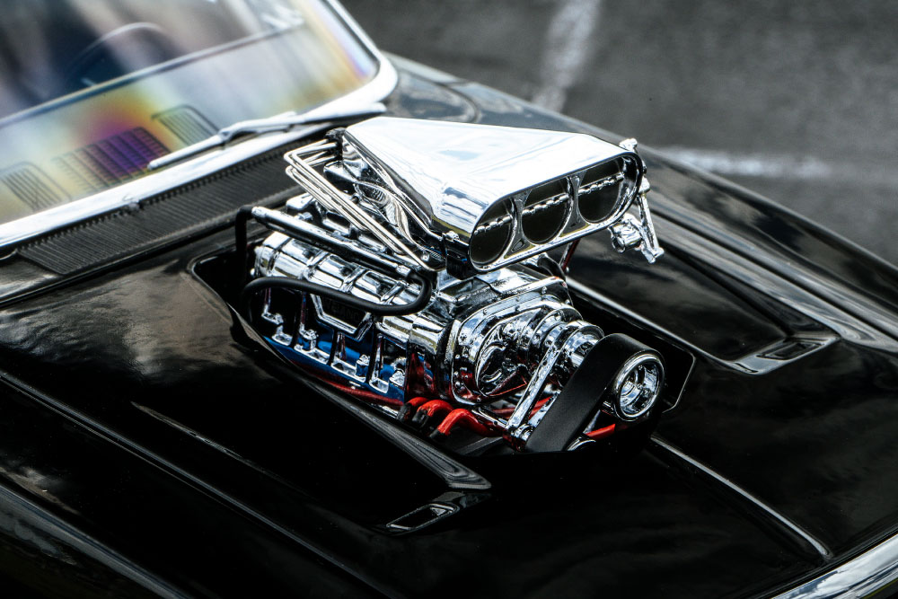 ボンネットから突き出ているのはスーパーチャージャー。3つ並んだ円形状の部分はスロットルに連動して開閉し、ここから空気を取り入れます。映画でもそんなシーンを見かけたことがあるのではないでしょうか。