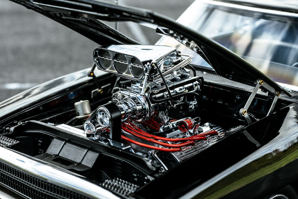 大きなボンネットを開けると、そこに収まるのはアメリカンマッスルカーの象徴とも言えるV8エンジン。各部をメッキ処理したエンジンルームは圧巻で、プラグコードのレッドやホース類のブルーが差し色として映えています。